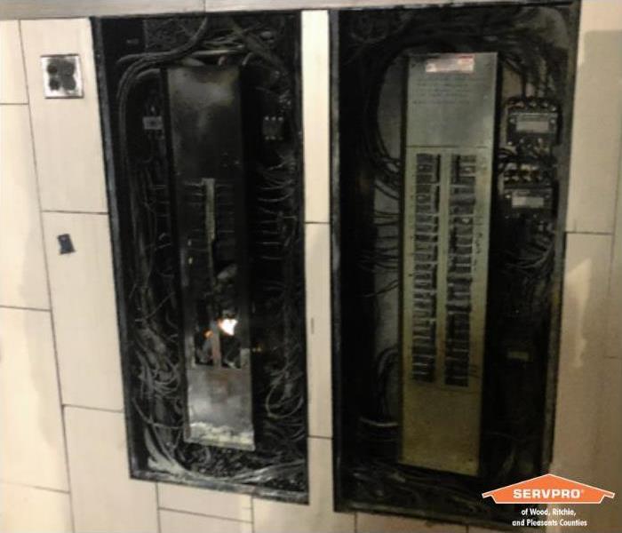 Electrical panels with the doors taken off. The insides of the panels are completely burned showing a black residue all over